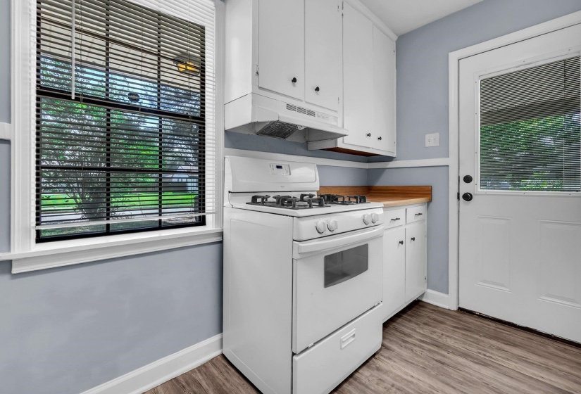 Kitchen featuring white cabinetry, a white gas range with overhead vent, wood-finish countertops, and wood-finish flooring