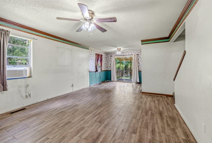 Spacious interior featuring wood-finish flooring, an overhead ceiling fan, and a large window