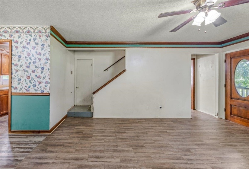 Spacious main living area featuring wood-finish flooring and a ceiling fan with integrated lighting