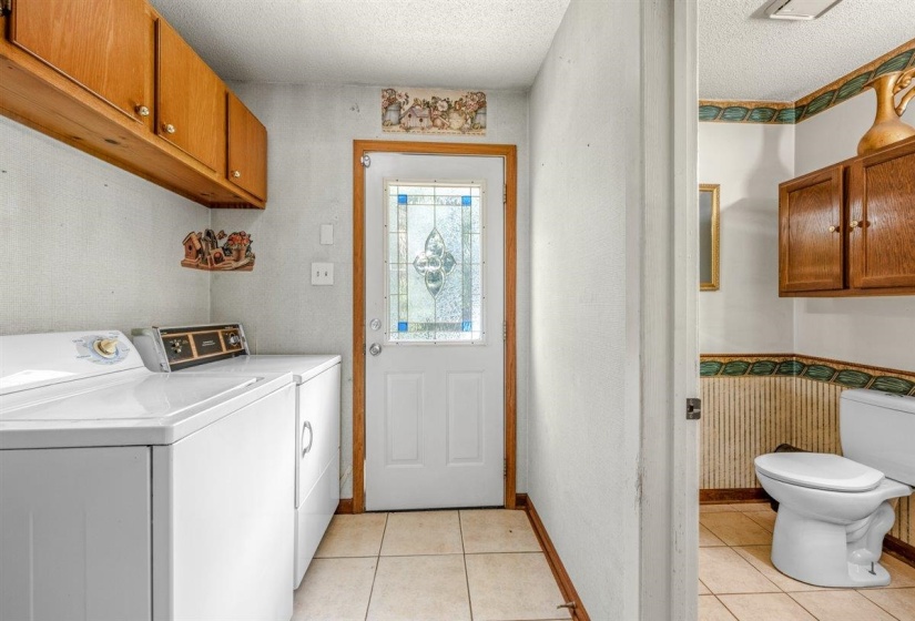 Laundry area featuring overhead wood cabinetry and tile flooring
