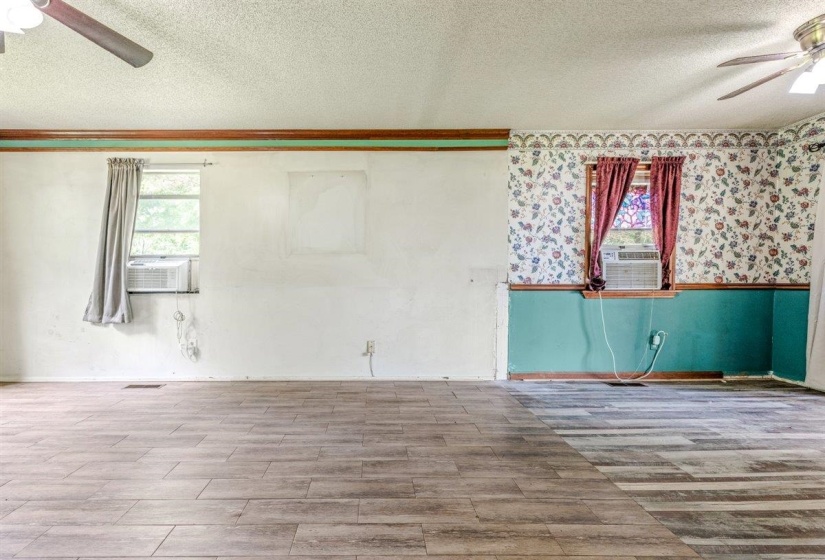 Spacious interior featuring wood-finish flooring, two windows providing natural light, and ceiling fans