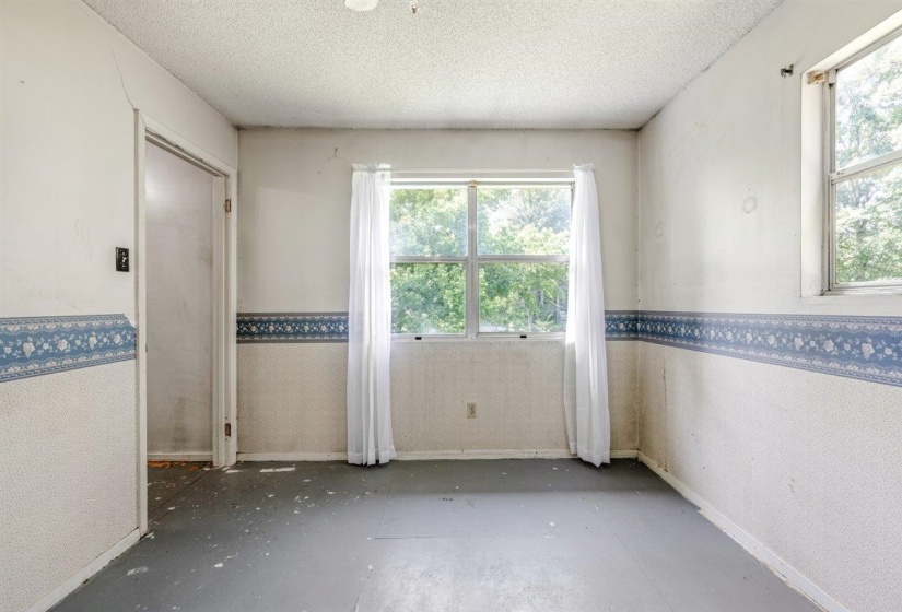 Spacious interior room with multiple windows providing natural light