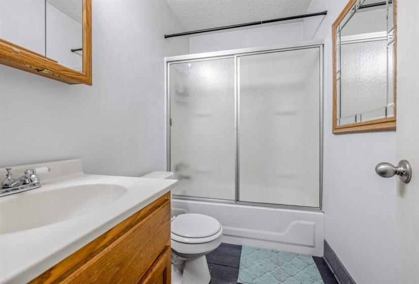Bathroom featuring a wood-finish vanity with an integrated sink and chrome faucet
