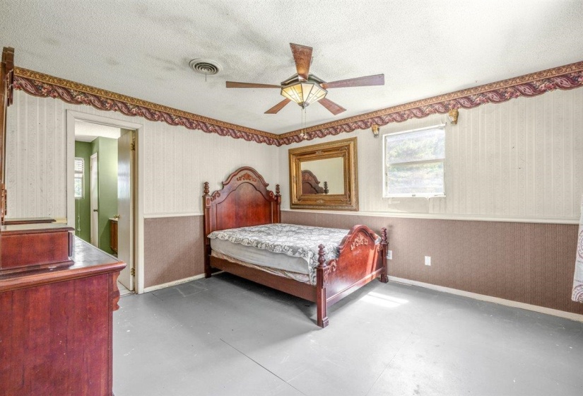 Room featuring a window, ceiling fan with integrated lighting, and a doorway opening to an additional interior space
