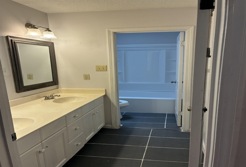 Double vanity with integrated sinks, brushed nickel fixtures, and a framed mirror