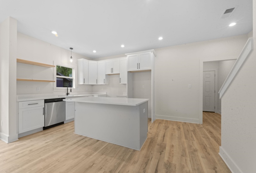 Kitchen with white cabinetry, a center island, stainless steel dishwasher, light wood-style floors, and open shelves