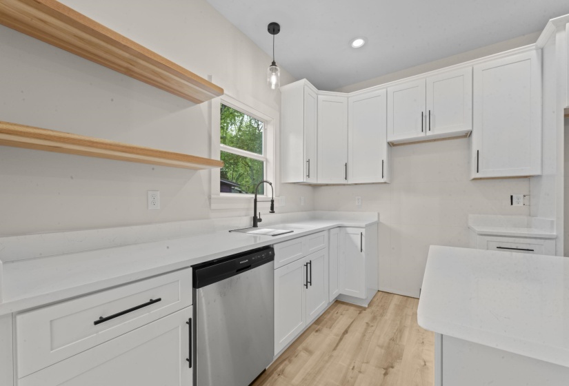 Kitchen featuring white cabinets, stainless steel dishwasher, light wood-style flooring, open shelves, and light stone counters