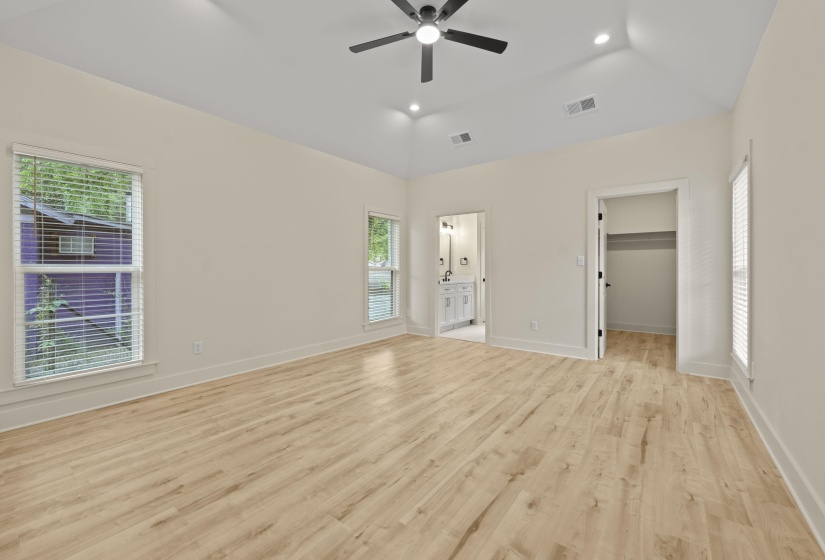 Unfurnished bedroom with a walk in closet, multiple windows, recessed lighting, light wood finished floors, and ceiling fan