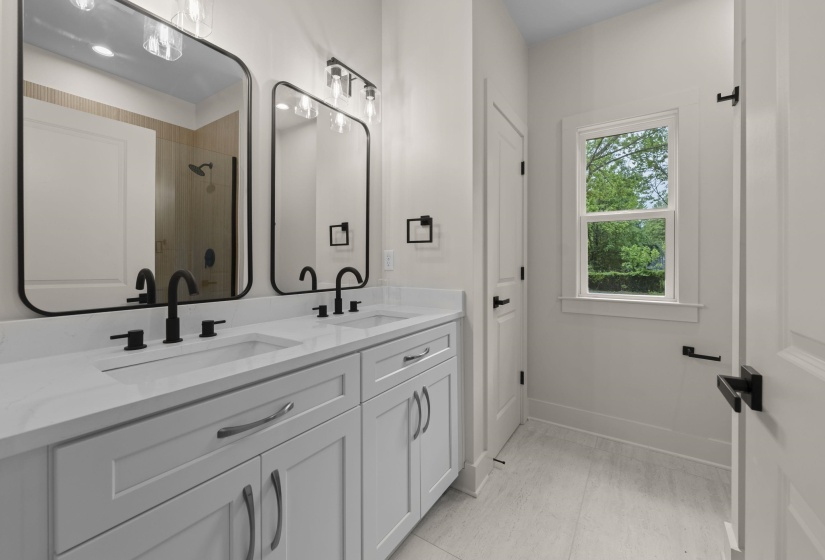 Bathroom featuring double vanity and a shower with door