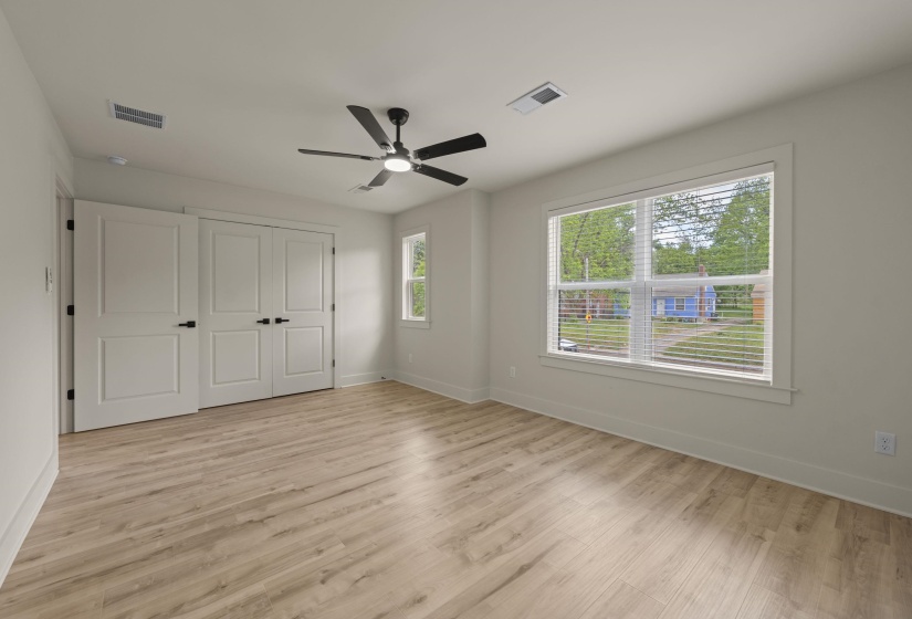 Unfurnished bedroom featuring light wood-type flooring, a closet, and a ceiling fan