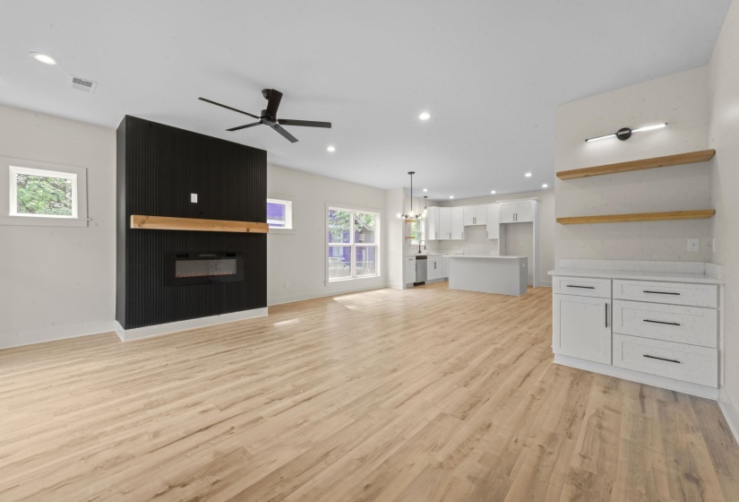 Unfurnished living room with ceiling fan, a fireplace, light wood-style floors, and recessed lighting
