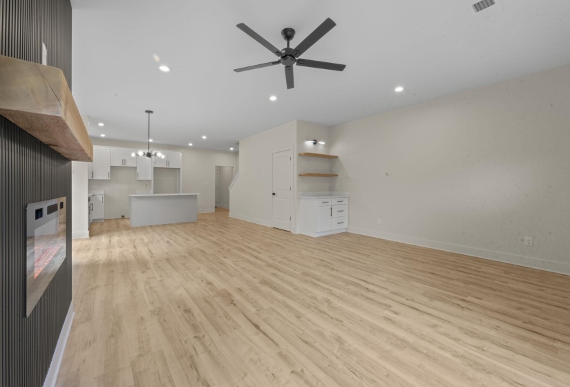 Unfurnished living room with hanging lights, light wood finished floors, and a ceiling fan