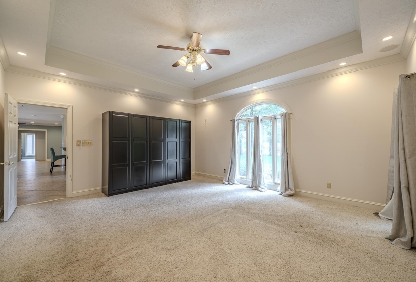 Carpeted room featuring a tray ceiling, recessed lighting, and a ceiling fan
