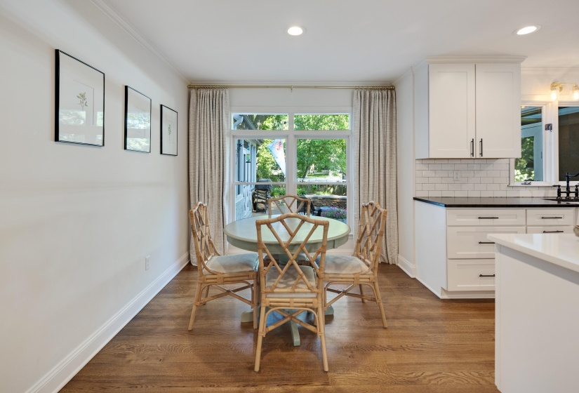Hardwood flooring throughout a dining area with recessed lighting