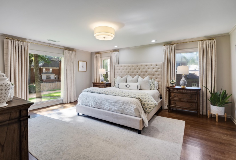 Spacious room featuring wood-finish flooring, a large picture window, a recessed ceiling light, and crown molding