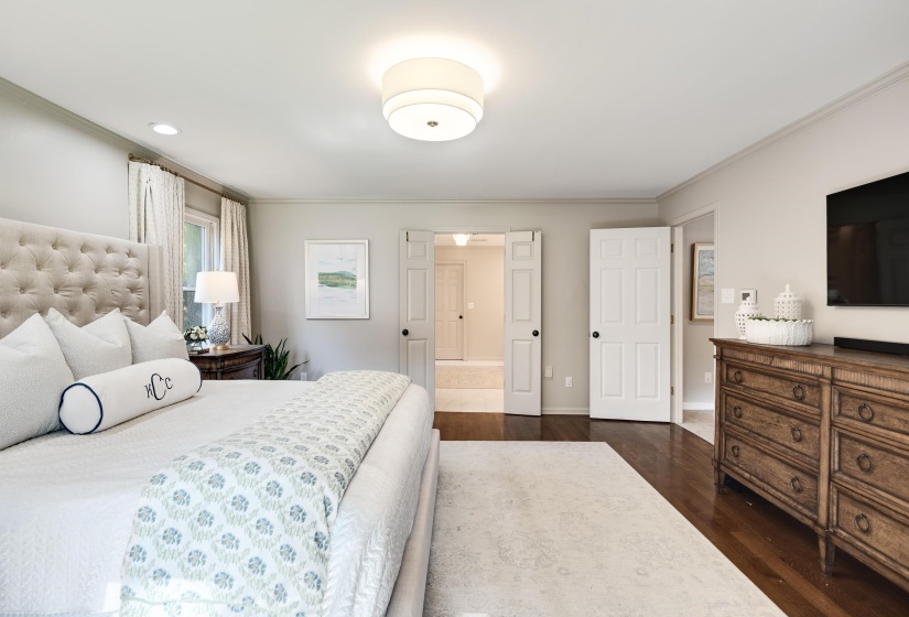 Spacious room featuring rich wood-finish flooring, light-toned walls, and a contemporary flush-mount ceiling light