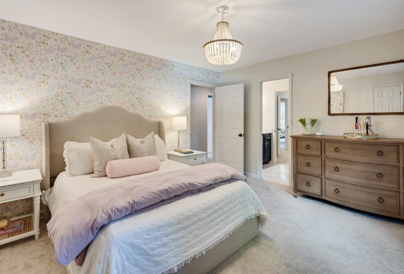 Bedroom featuring wall-to-wall carpeting and a decorative chandelier