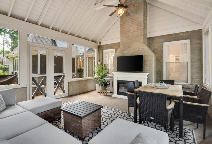 Screened porch with vaulted wood-plank ceiling, exposed white beams, and a ceiling fan