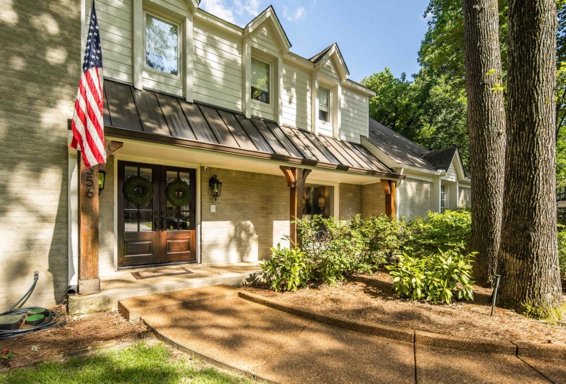 Stone and siding exterior with a metal awning over the entryway