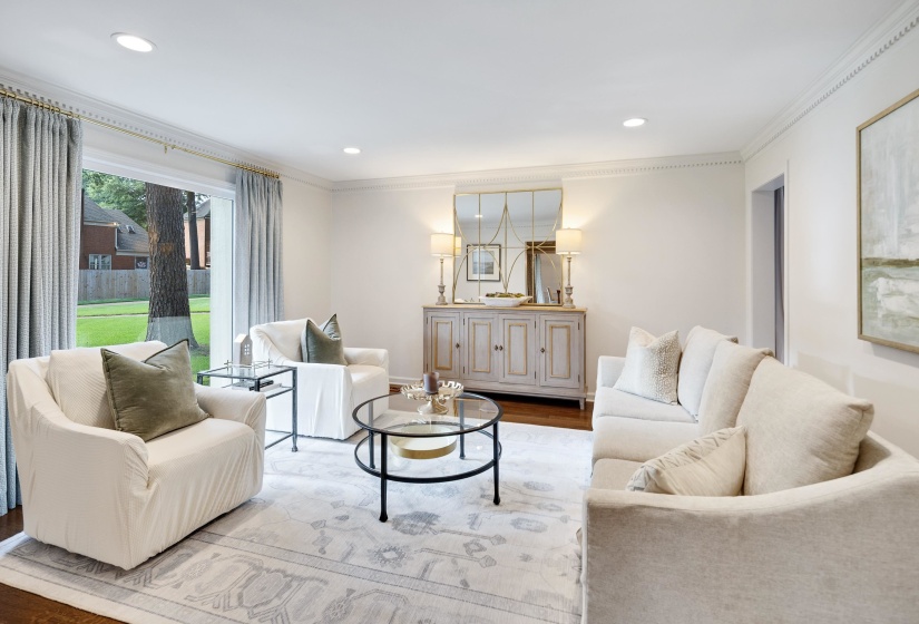 Bright living space featuring recessed lighting, crown molding, and wood-finish flooring