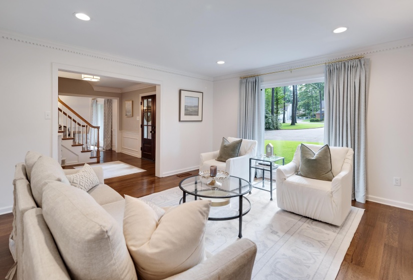 Spacious living area featuring wood-finish flooring, recessed lighting, and crown molding