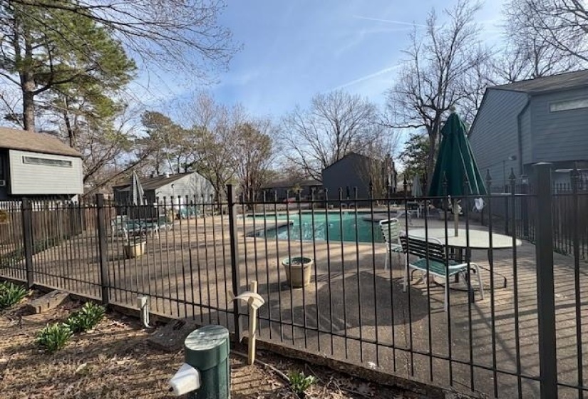 Fenced outdoor swimming pool with surrounding concrete decking