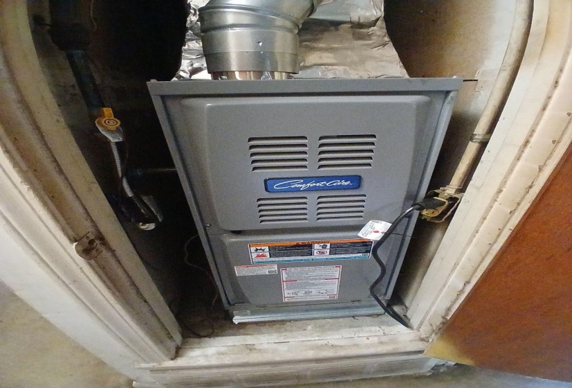 Comfort Care furnace with metal ductwork and visible utility lines