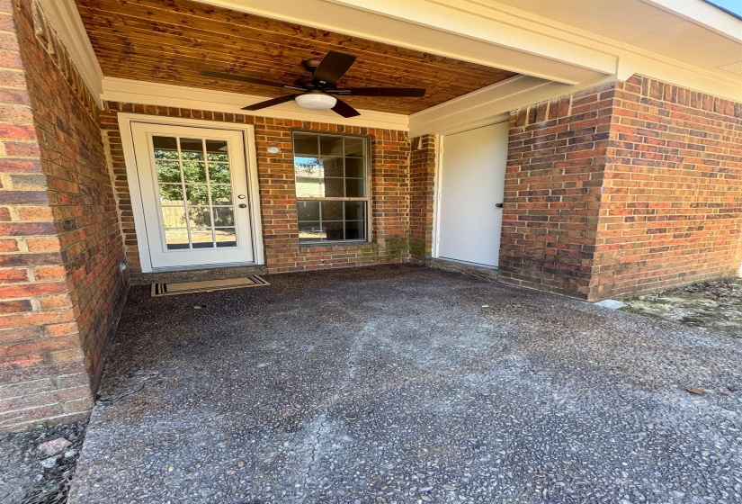 Covered patio featuring a wood-finish ceiling, a ceiling fan with integrated lighting, and a brick exterior