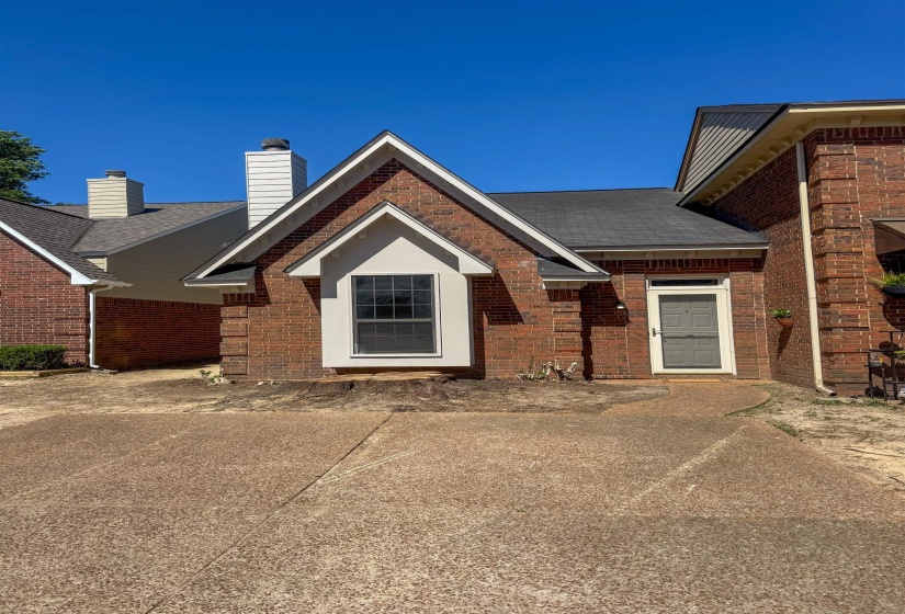 Brick exterior with a prominent front gable and a contrasting light-colored entry door