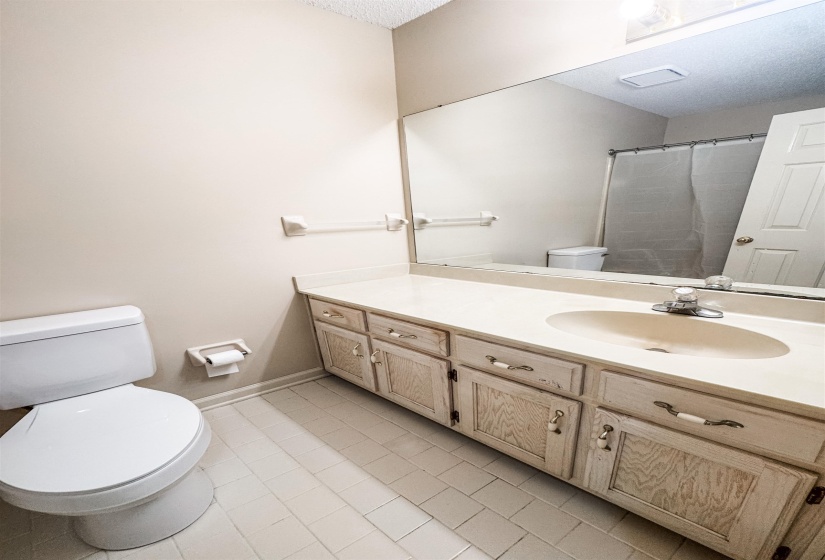 Bathroom featuring a vanity with a drop-in sink, an expansive mirror, and tile flooring