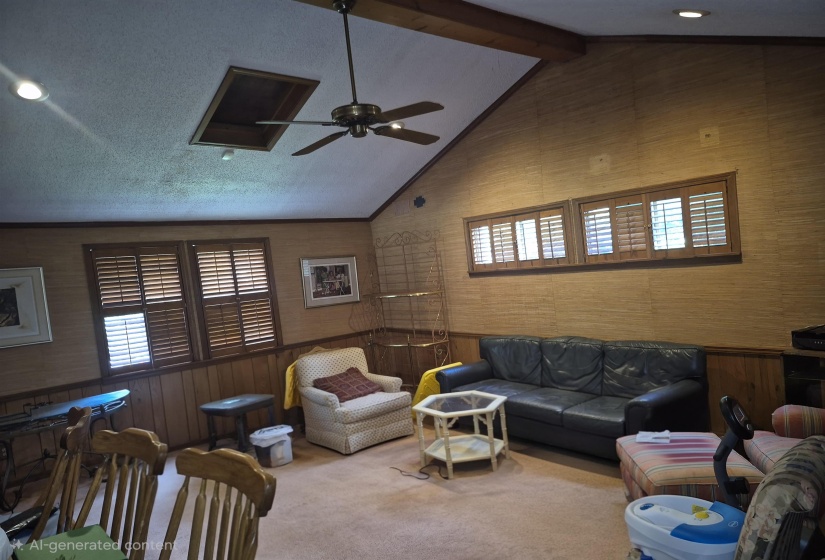 Vaulted ceiling with exposed wood beam, recessed lighting, and a ceiling fan