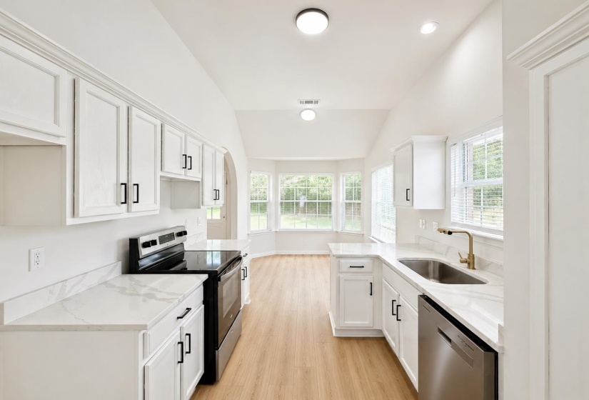 Kitchen featuring white cabinetry with matte black hardware, white countertops, and stainless steel appliances