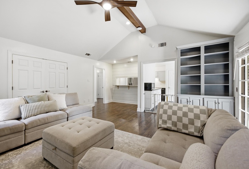 Vaulted ceiling featuring a wood-finish beam and ceiling fan