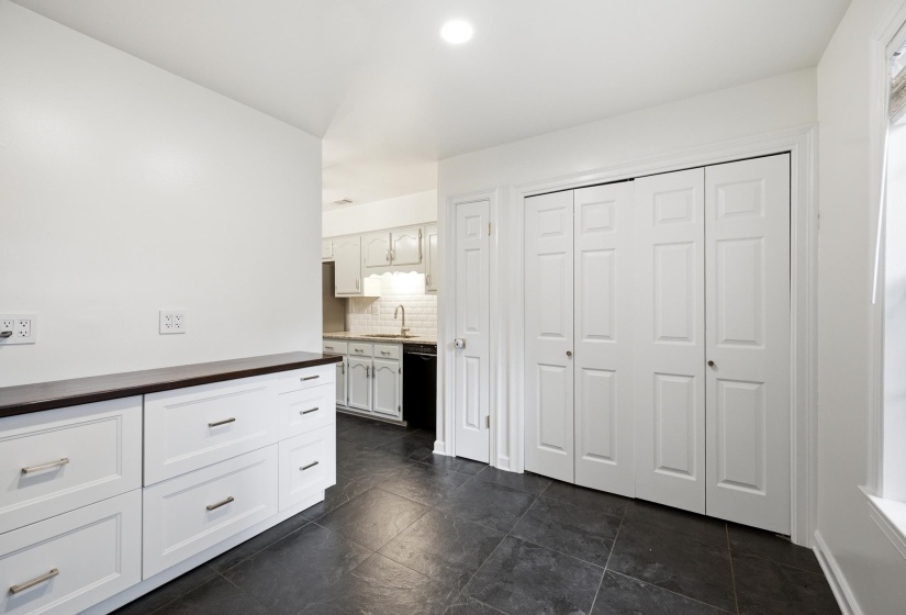 Built-in white cabinetry with a dark countertop and brushed nickel hardware