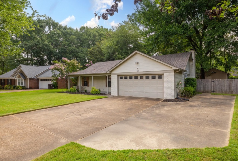 Single-story residence featuring a painted brick and siding exterior, an attached garage, and a covered front porch