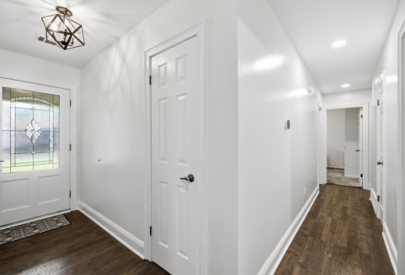 Entryway featuring a decorative glass panel door and wood-finish flooring
