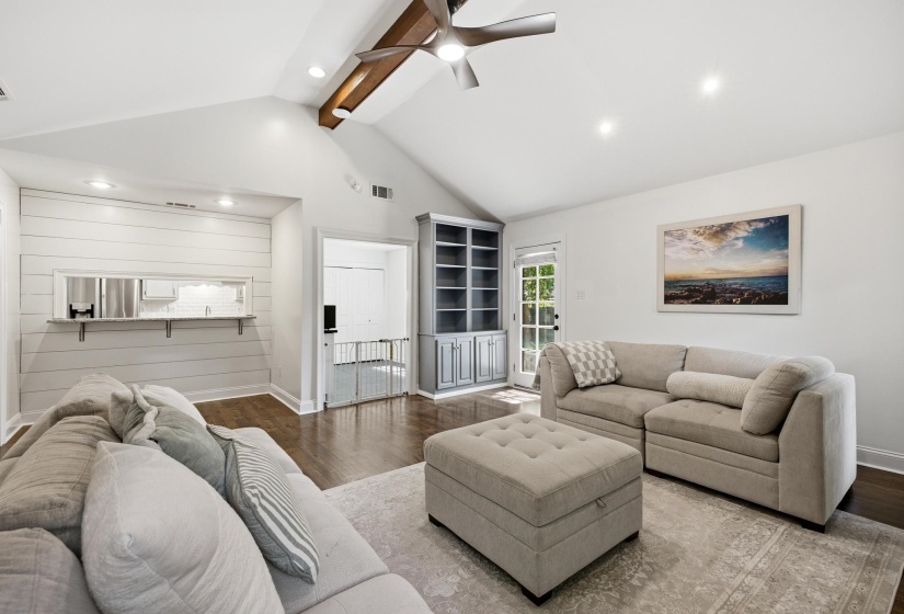 Vaulted ceiling with an exposed wood beam and ceiling fan