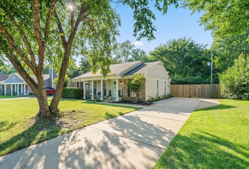 One-story property featuring a columned front porch, a light-colored brick facade, and a complementary siding finish