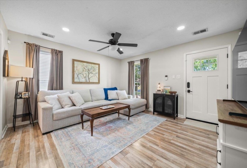 Living area featuring light wood-finish flooring, recessed lighting, and a contemporary ceiling fan
