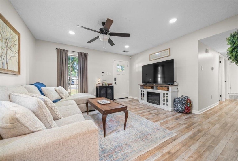 Living area featuring wood-finish flooring, recessed lighting, and a ceiling fan