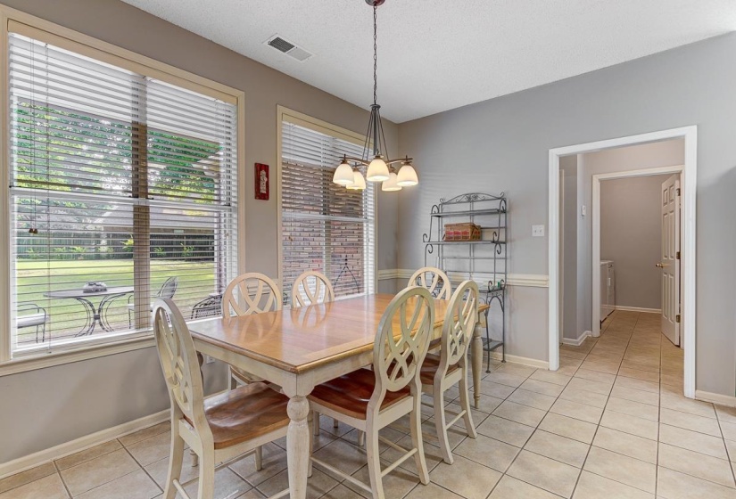 Dining area featuring tile flooring, neutral wall tones, a contemporary chandelier, and large windows with blinds