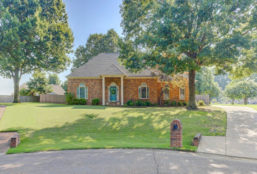 Brick exterior residence featuring a covered entry porch supported by white columns
