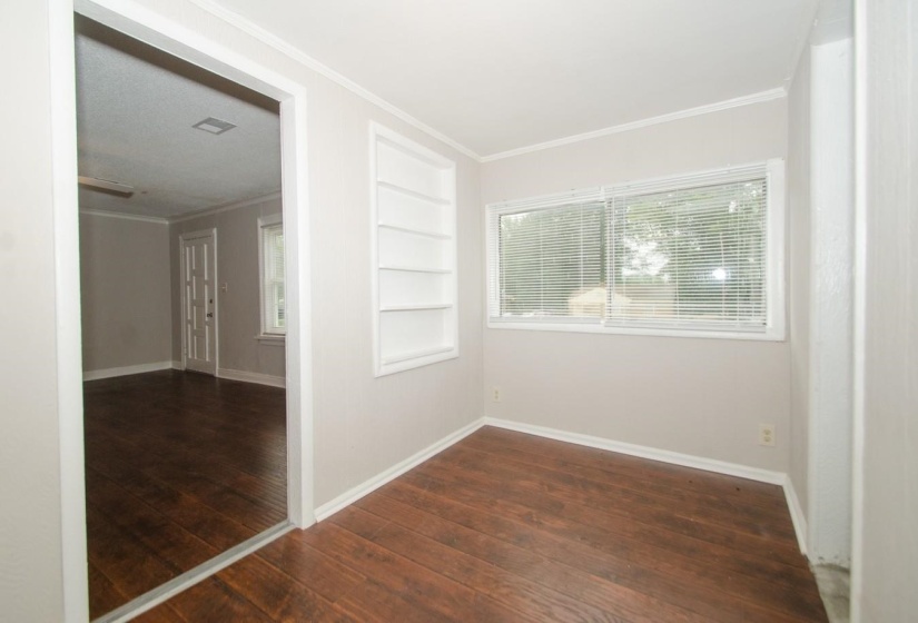 Room featuring wood-finish flooring, light neutral wall color, and white trim