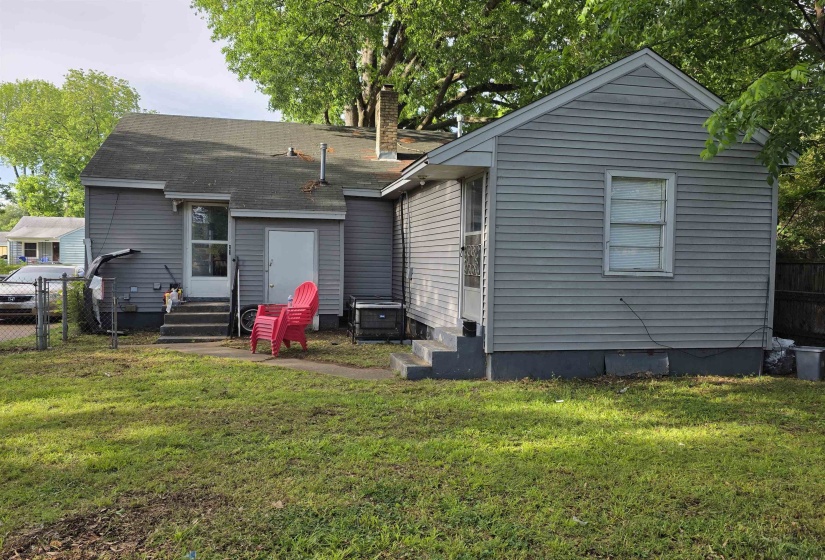 Grey siding exterior with a partial chain-link fence