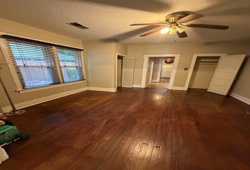 Hardwood flooring extending throughout, complemented by a ceiling fan with integrated lighting
