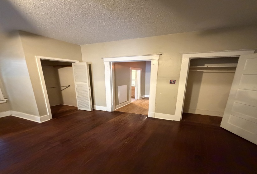 Interior space featuring dark wood-finish flooring, light neutral wall tones, and white trim