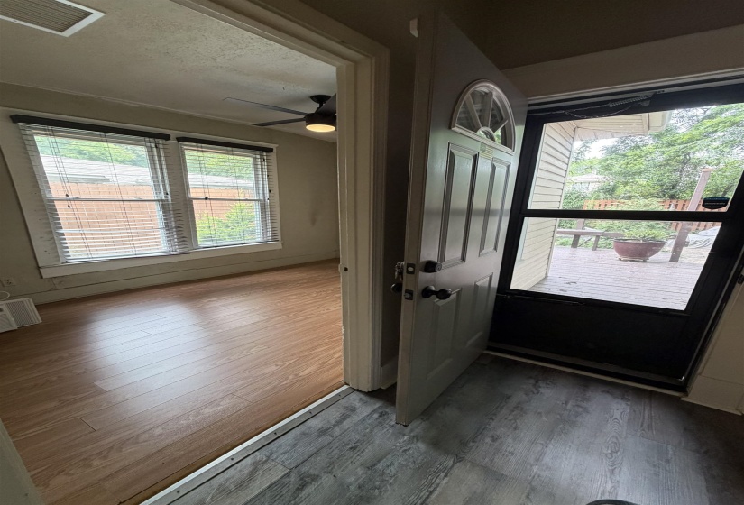 Entryway with wood-finish flooring, half-lite door, and screen door access to a deck
