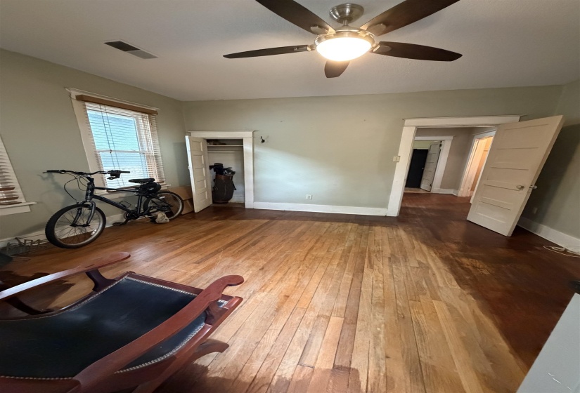 Room featuring wood flooring, neutral wall paint, and a ceiling fan