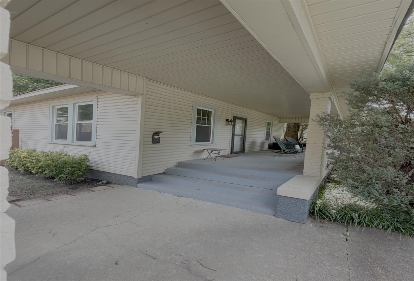 Covered front porch featuring a painted concrete surface and a paneled ceiling