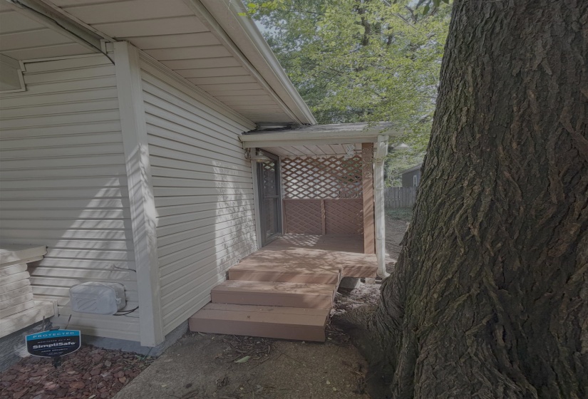 Covered porch entry featuring wood lattice privacy screens, composite decking, and stepped access